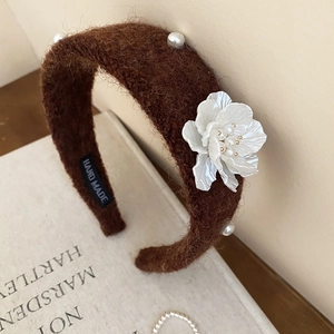 Close-up of handmade brown velvet headband with white flower and elegant pearls