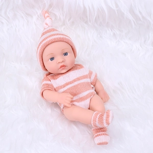 Realistic 20cm reborn baby doll wearing pink striped knit outfit on white fur blanket