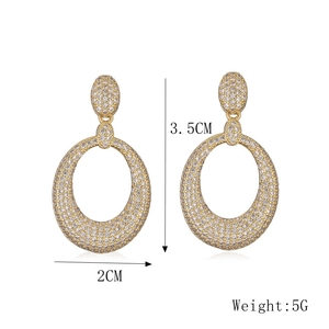 Vue détaillée de boucles d'oreilles ovales dorées avec zircone et dimensions de 3,5 cm