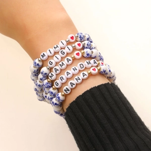 Dettaglio di cinque braccialetti in perline di ceramica con lettere MIMI GIGI MAMA GRANDMA NANA
