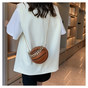 Brown basketball-shaped shoulder bag featuring gold chain straps and textured finish