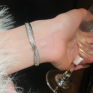 Vue détaillée d'un bracelet infini argenté serti de zircons porté avec une allure élégante