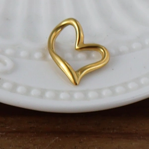 Gros plan détaillé d'un pendentif en forme de cœur évidé en acier doré 24 carats