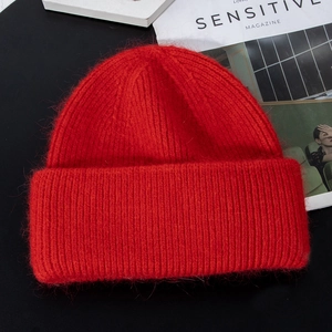 Close-up of vibrant red knitted beanie with soft mohair texture and thick warm design