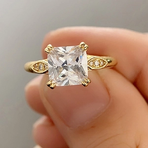 Eleganter goldener Ring mit quadratischem Stein und Olivenblatt-Besatz für Verlobungen