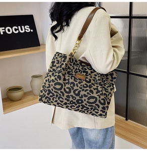 Detail of leopard print tote bag with brown leather strap and metal chain links