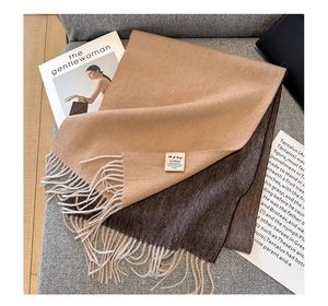 Close-up of dual-tone camel wool scarf showing 100% Australian wool tag and fringe detail