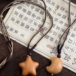 Handcrafted wooden star and moon pendant necklace with woven cord and elegant bead details