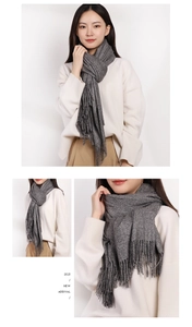Detail of thick grey cashmere-like scarf showing texture and fringe on a casual outfit