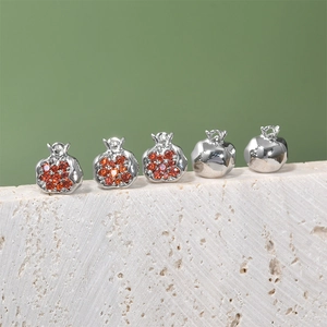 Detailed macro view of 14K gold plated pomegranate charms with red zircon stones