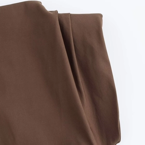 Macro shot of dark brown suit fabric texture with elegant pleated drape and fine weave
