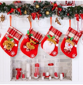 Vue détaillée de quatre chaussettes de Noël avec motifs 3D suspendues à la cheminée