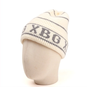Detail of knitted beanie showing vertical ribbing texture and XBGX letter pattern