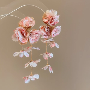 Detailed close-up of pink floral chiffon tassel earrings with elegant gold metal finish