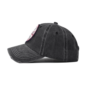 Detail of vintage washed cotton baseball cap with embroidered patch and distressed brim