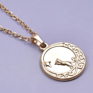 Close-up of 18k gold plated cat relief pendant with moon and star details on chain