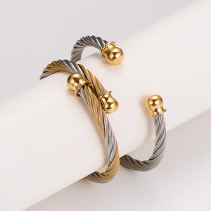 Minimalist cable wire bangle in stainless steel with gold ball ends for men and women