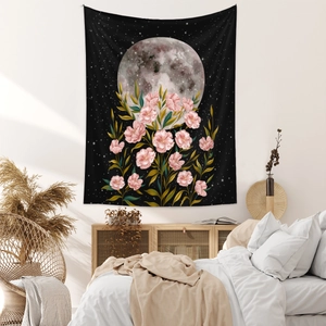 Detail of bohemian moon phase tapestry with pink flowers and starry night on a cozy wall