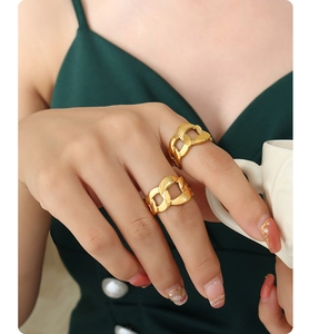 Detail of 18K gold-plated chunky chain link rings on model holding a ceramic cup