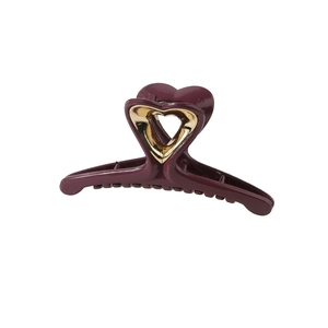 Close-up of heart-shaped cutout hair claw clip in elegant burgundy with gold finish