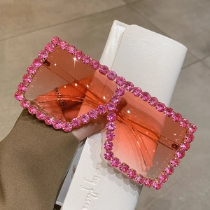 Oversized pink rhinestone sunglasses with gradient lenses and white leather case