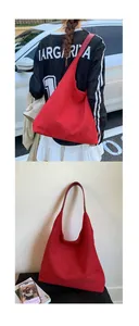 Detail view of large red suede hobo tote bag showing wide shoulder strap and spacious interior