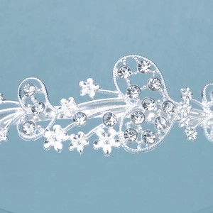 Detailed close-up of sparkling rhinestones and butterfly patterns on a silver headband