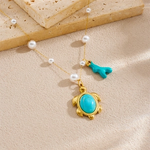 Collana dorata con perle e ciondoli a forma di tartaruga turchese e corallo