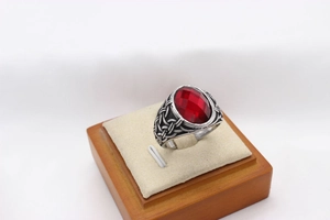 Macro detail of vintage viking ring featuring oval red gemstone and carved silver band