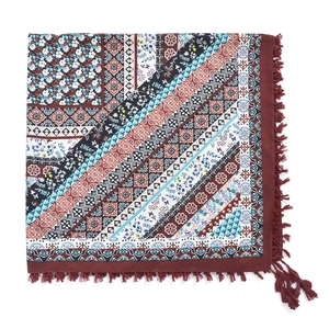 Close-up of bohemian square scarf featuring geometric patterns and knotted tassel edges