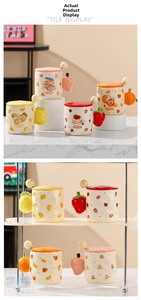 Detail of creative ceramic fruit mugs featuring strawberry and peach themed lids and spoons