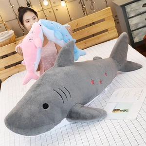 Detail of plush shark toys in gray, blue and pink with embroidered eyes and star decor