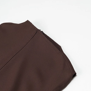 Detail of the high collar brown sleeveless dress showing fabric texture and shoulder zipper