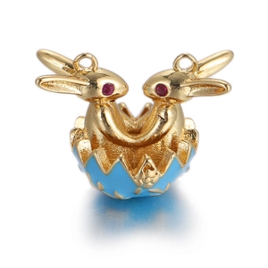 Detail of golden double bunny charm in blue enamel Easter egg with red gemstone eyes