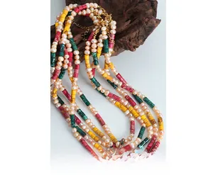 Close-up of handmade freshwater pearls and colorful marbled beads on wood