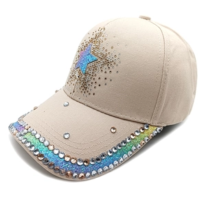 Close-up of beige baseball cap with rhinestone star and gradient sequin brim detail
