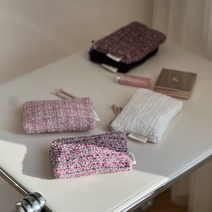 Close-up of textured tweed mini pouches for lipstick and earphone storage