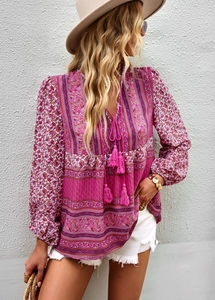 Close-up of V-neckline with tassel ties and bohemian paisley print on women's blouse