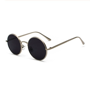 Détail de lunettes de soleil rondes vintage avec monture en métal doré et verres