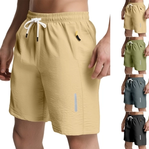 Detail of quick-dry sports shorts featuring reflective strips and secure zipper pockets