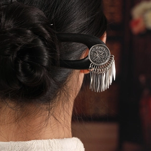 Handmade ebony U-shaped hairpin with silver hollow metal pattern and tassel on a bun