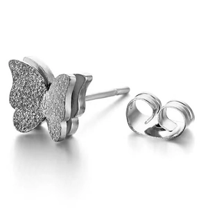 Macro detail of silver bow earring featuring sandblasted wings and polished steel finish