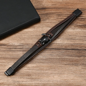 Detail eines Vintage-Lederarmbands mit schwarzem Schildkrötenanhänger und Magnetverschluss