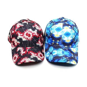 Detail view of tie-dye baseball caps with red floral and blue marble patterns