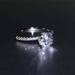 Macro detail of silver ring with round brilliant cut solitaire stone and side diamonds