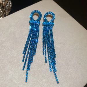 Detailed macro view of blue zircon crystal tassel earrings with sparkling silver chains