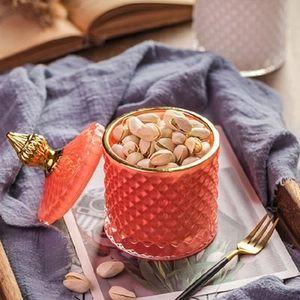Pink diamond-textured glass storage jar with elegant gold trim in a cozy scene