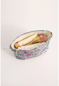 Macro detail of French vintage jacquard makeup bag showing floral embroidery and inner lining