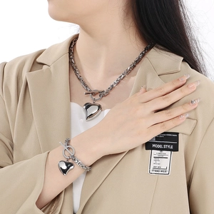 Silver Byzantine chain set with hollow heart pendant and toggle clasp on a model