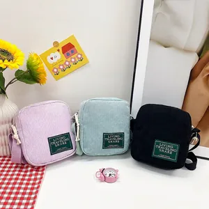 Three corduroy crossbody bags in pink, blue and black with soft texture and knotted straps